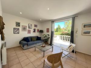 a living room with a blue couch and a glass table at Adorable maison de vacances plain pied au coeur de la station et proche des plages 4 chambres, jardin, WIFI, LXDUNE1 in Portiragnes