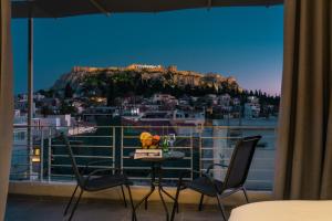 a room with a balcony with a view of a mountain at 24K Athena Suites in Athens