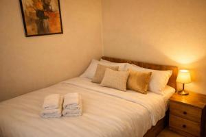 a bedroom with a bed with two towels on it at Wood Retreat in Valea Bradului
