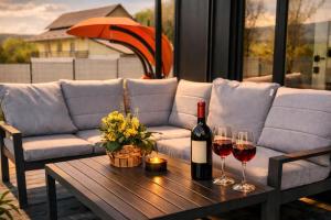 a couch and two glasses of wine on a table at Wood Retreat in Valea Bradului