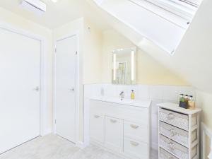 a white bathroom with a sink and a mirror at Dunroamin Bed and Breakfast in Aviemore +55 photos