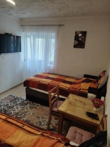 a living room with two beds and a table at Apartmani Konta in Livno