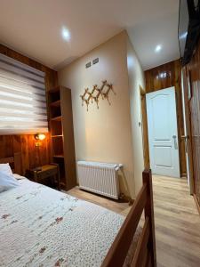 a bedroom with a large bed and a door at Hostal Graciela in Pucón