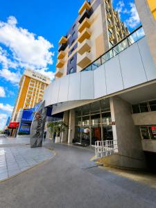 a building with a sign in front of it at Novo Santoni Hotel Guarapuava in Guarapuava