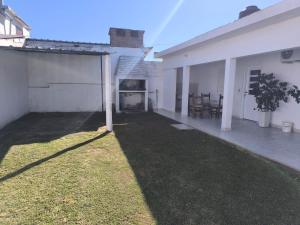 a backyard of a white house with a fireplace at Departamento Don Nico in San José de la Dormida