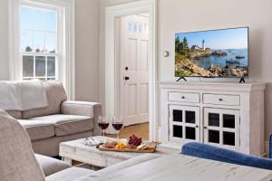 a living room with wine glasses and a tv at Charming Kennebunk Cape - Walk to Dock Square! in Kennebunk