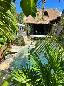 a swimming pool in front of a house at Aldea Pukna Tulum in Akumal