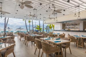 um restaurante com mesas e cadeiras e vista para o oceano em Henann Prime Beach Resort em Boracay