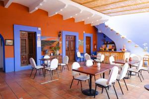 a restaurant with tables and chairs and an orange wall at Casa de Siete Balcones Hotel Boutique in Oaxaca City