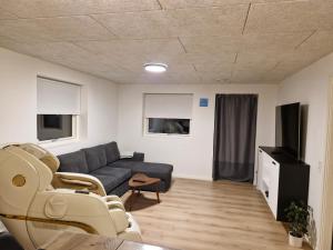 a living room with a couch and a tv at New apartment, only 4 km from the highway in Horsens