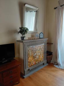 a living room with a fireplace with a mirror at Berny House in Bracciano