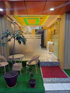 a lobby with a table and chairs and a tree at CG Hotel in Kathmandu