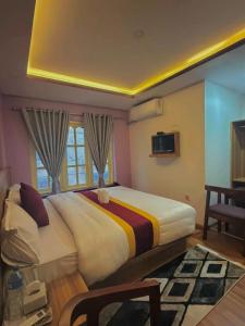 a bedroom with a large bed and a window at CG Hotel in Kathmandu