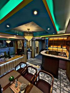 a dining room with a bar with a table and chairs at CG Hotel in Kathmandu +1 photo