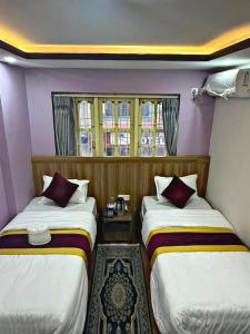 a room with two beds and a window at CG Hotel in Kathmandu