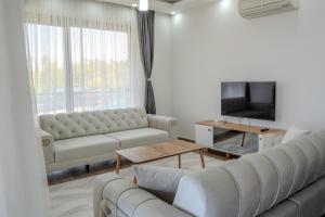 a living room with a couch and a tv at Lale Saray Sapanca in Sapanca
