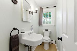 a white bathroom with a sink and a toilet at Charming Kennebunk Cape - Walk to Dock Square! in Kennebunk +97 photos