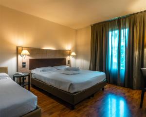 ein Hotelzimmer mit zwei Betten und einem Fenster in der Unterkunft San Giorgio, Sure Hotel Collection by Best Western in Forlì + 69 Fotos