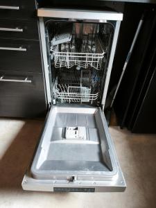 an empty dishwasher with its door open in a kitchen at Studio des 3 bassins in La Chapelle-Blanche +15 photos