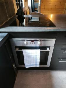 a kitchen with an oven with a white towel on it at Studio des 3 bassins in La Chapelle-Blanche