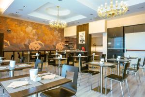 ein Restaurant mit Tischen und Stühlen und einem Wandgemälde in der Unterkunft San Giorgio, Sure Hotel Collection by Best Western in Forlì
