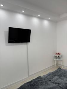 a living room with a tv on a white wall at Diamond apartment in Kikinda