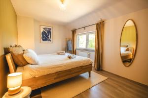 a bedroom with a bed and a large mirror at Private spa - La Sparenthèse in Ciney