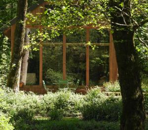 a wooden pergola in the middle of a garden at La Cabane du Gardien in Marche-en-Famenne