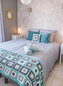 a bedroom with a bed with blue pillows on it at La villa Margats - Charme & détente en bord de mer in Bray-Dunes +10 photos