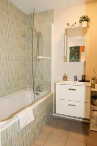 a bathroom with a tub and a sink at La villa Margats - Charme & détente en bord de mer in Bray-Dunes