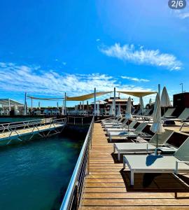 a row of lounge chairs on a dock with water at Blue Marlin 6 in Pasito Blanco