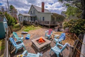 a group of chairs around a fire pit in a yard at Charming Kennebunk Cape - Walk to Dock Square! in Kennebunk