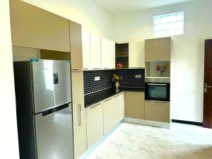 a kitchen with white cabinets and a stainless steel refrigerator at cassiopeia escape in Kottawa