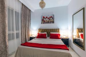 a bedroom with a large bed with red pillows at VIP Home in El Aouina Station
