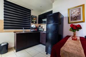 a kitchen with a black refrigerator next to a table at VIP Home in El Aouina Station +21 photos
