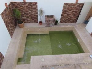 a large pool of water in a room with plants at Casa Las Brisas in Progreso