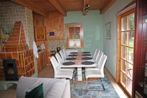 a dining room with a table and white chairs at Anglo-Polish Holidays in Chycina