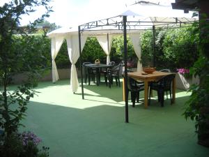 un patio con mesas y sillas bajo una sombrilla blanca en Giorno&Notte Colleferro, en Colleferro