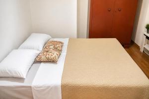a bed with two pillows on it in a room at Balkan House in Mostar