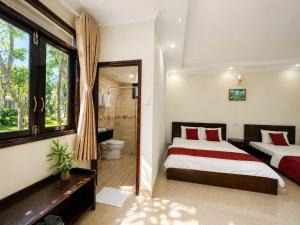 a bedroom with two beds and a bathroom with a shower at Cửu Long Beach Phú Quốc in Phú Quốc