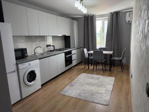 a kitchen with a table and a washing machine at Kogălniceanu 23 in Căuşeni