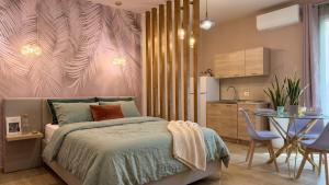 a bedroom with a bed and a table and a kitchen at Almantra Rooms - Valle dei Templi e Mare in Favara