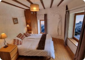 a bedroom with a bed and a large window at Chalet Broski - Spacious Chalet with Hot Tub, Sauna & BBQ in Planvillard