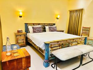 a bedroom with a bed and a table and a bench at Atithi Leopard Camp - Jawai in Sānderao