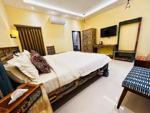 a bedroom with a large bed and a television at Atithi Leopard Camp - Jawai in Sānderao