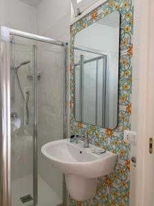 a bathroom with a sink and a shower with a mirror at Sea Breeze Terrace in Monopoli +65 photos