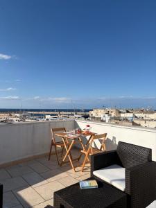 a patio with a table and chairs on a roof at Sea Breeze Terrace in Monopoli