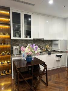 a kitchen with a table with a vase of flowers on it at 7Homestay in Hai Phong