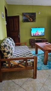 a living room with a couch and a table at EBENEZER Apartment in Diani Beach