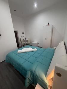 a bedroom with a bed with a blue blanket on it at B & B Yaya in Taranto +8 photos